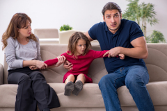 Young couple and their daughter in family conflict concept